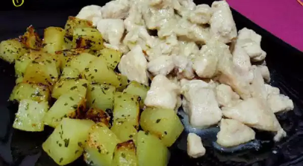 Raxo de pollo cremoso con patatas asadas y hierbas. Un plato casero que invita a disfrutar.