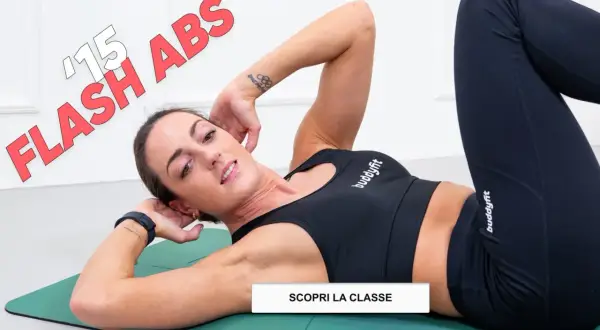 Donna in tenuta sportiva esegue crunch per migliorare il tono muscolare addominale. Testo "15 FLASH ABS" in sovrimpressione.