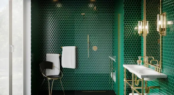 Ekskluzywna łazienka w stylu art deco. Ściany pokryte zielonymi, heksagonalnymi płytkami, złote detale, podwójna umywalka i stylowe oświetlenie tworzą luksusową atmosferę.
