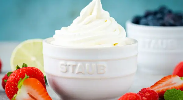 Cremiger Frozen Joghurt, frisch aus der Eismaschine, umgeben von saftigen Erdbeeren und Blaubeeren.