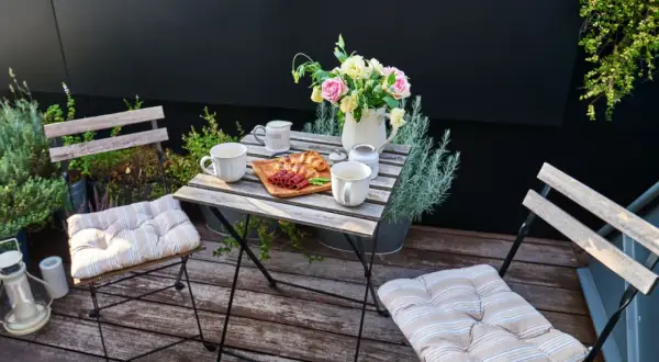 Drewniany, nowoczesny balkon z kawą i śniadaniem.