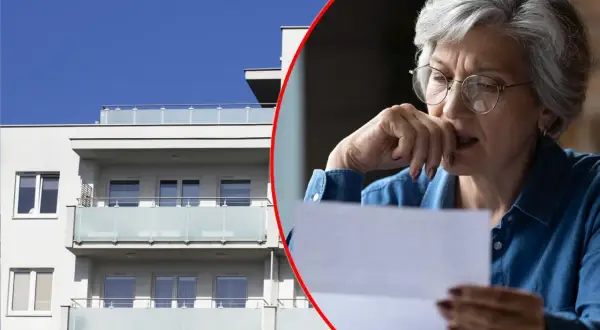Zmartwiona kobieta czyta list przed nowoczesnym budynkiem, być może dotyczy to jej mieszkania TBS.
