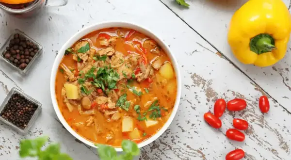 Aromatic gulasz, idealny na dietę trzustkową, z kawałkami mięsa, ziemniaków i papryki, ozdobiony natką pietruszki.