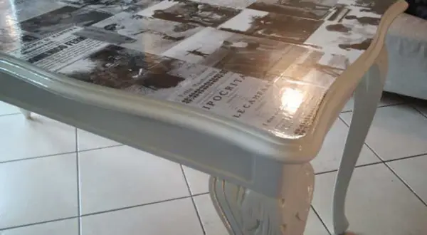 Tavolo antico trasformato con collage di giornali d'epoca sotto resina trasparente: un modo moderno per dare nuova vita ai mobili.