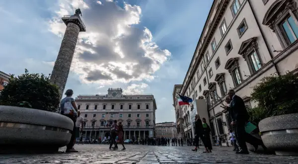 La Colonna di Marco Aurelio domina la piazza, con edifici storici e persone che passeggiano a Piazza Colonna, Roma.