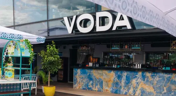 Warszawa knajpy z klimatem: bar VODA z niebieskim marmurowym blatem i butelkami ginu na wózku.