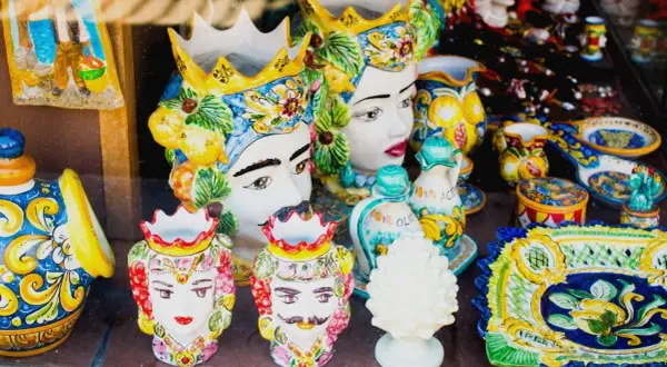 Ceramiche siciliane con teste di moro, vasi decorati e piatti colorati, un'esplosione di arte che ricorda il fascino di Palermo.