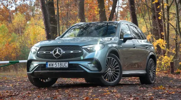Szary Mercedes GLC 300 4Matic na tle jesiennego lasu.