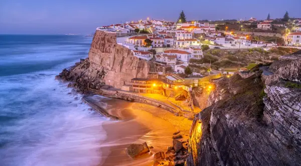En pittoresk kuststad i Portugal, med vita hus på klipporna och en strand nedanför. Ett perfekt portugal resmål.