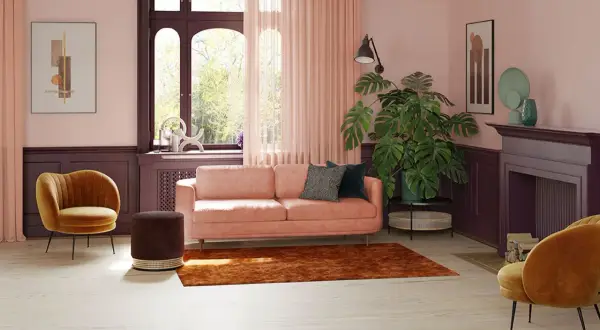 Przytulny salon z sofą w kolorze pudrowy róż, aksamitnym fotelem i dywanem w odcieniu cegły.