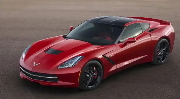 Czerwony Chevrolet Corvette Stingray z czarnym dachem na torze wyścigowym.