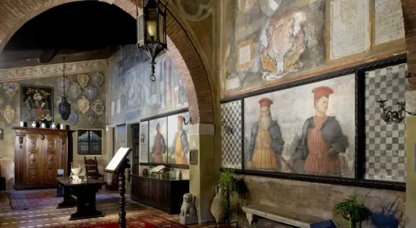 Interno del castello di Drugolo con affreschi storici, ritratti di nobili e arredi antichi.