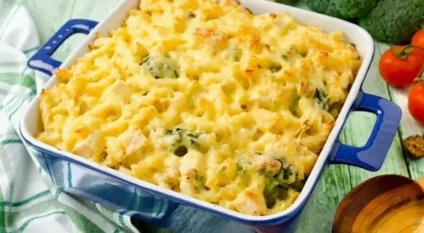 Gratinerad pasta med broccoli och kyckling i en blå ugnsform. Perfekt vegetarisk mat för barn, som ser både god och inbjudande ut.