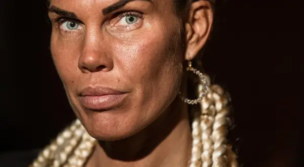 Michaela Lauren med blå ögon och flätor. Hon bär en stor, glittrig örhänge.