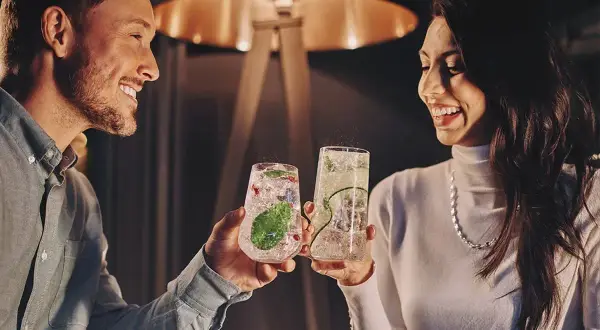 Para wznosi toast drinkami, szukając inspiracji na białystok atrakcje dla par.