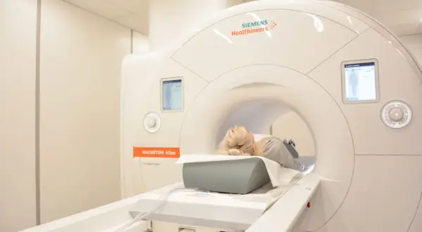 Pacjentka leży w aparacie do rezonansu magnetycznego. Badanie to nie wykorzystuje promieniowania jonizującego.