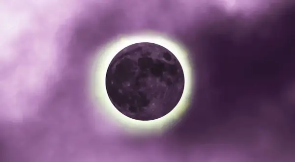 Luna nueva en tonos morados, con un halo brillante. Representa el inicio de ciclos y el luna nueva significado espiritual.