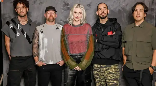 Pięciu członków zespołu Linkin Park pozuje do zdjęcia na tle szarej ściany.