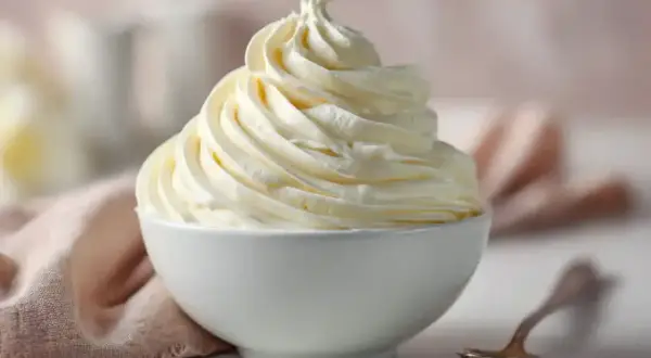 Une délicieuse crème au beurre meringue suisse, aérienne et onctueuse, dressée dans un bol blanc.