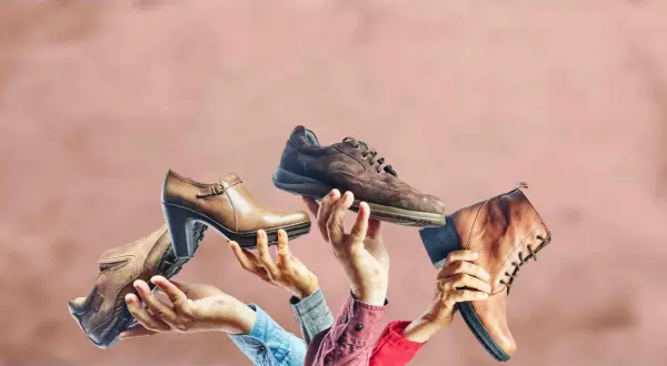 Różne buty trzymane w dłoniach, jakby na pokaz. Czy to symboliczne odniesienie do przesądów o butach i ich znaczeniu?