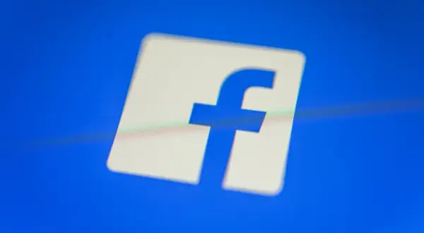 Logo Facebooka na niebieskim tle.