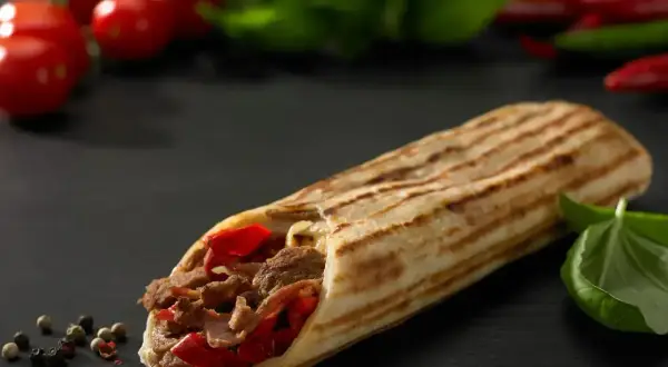 Pyszny kebab z mięsem i papryką, idealny na szybki posiłek. Zastanawiasz się, ile kosztuje kebab?
