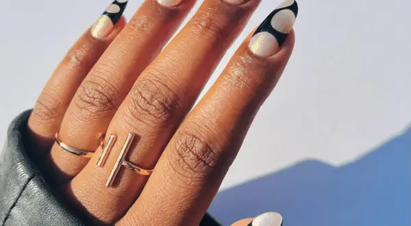 Unghie lunghe e affusolate con decorazione a pois bianchi e neri, realizzate con acrygel. Brillanti e alla moda.