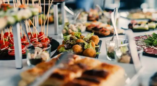 Un apéro dinatoire enceinte, avec des verrines, des brochettes de tomates cerises, des boules de fromage et des tartines.