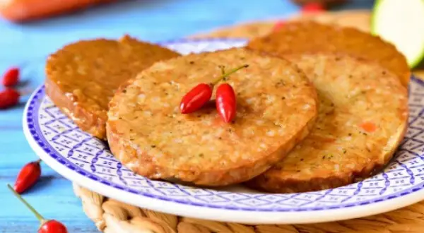 Plasterki seitanu, smażone na złoto, ozdobione dwoma małymi papryczkami chili. Idealne do wegańskich burgerów.