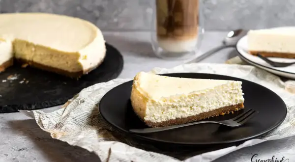 Ein Stück New York Cheesecake, cremig und auf einem Keksboden, wartet auf dich. Dieses Rezept ist ein Genuss!