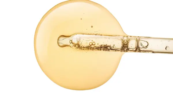 Goldgelbes Serum mit Pipette, das für strahlende Haut sorgt. Vitamin C Haut vorher-nachher: Ein Tropfen für sichtbare Ergebnisse.