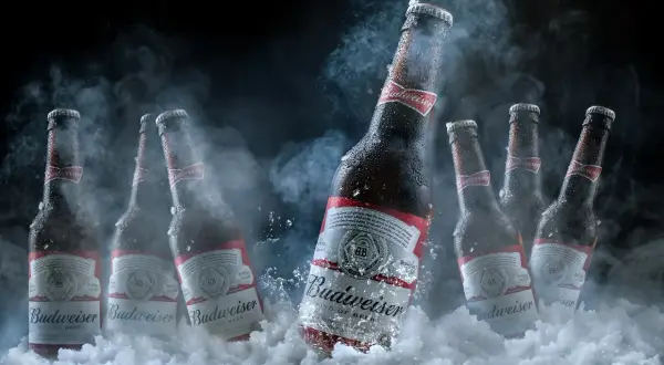 Butelki piwa Budweiser w lodzie i dymie. Czy można pić piwo które zamarzło? To pytanie pozostaje otwarte, ale zimne piwo zawsze smakuje wybornie.