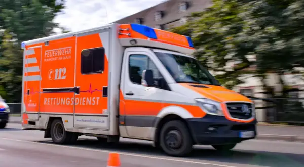 Feuerwehr-Rettungsdienst-Fahrzeug in Frankfurt am Main rast heran. Hoffentlich merkt man einen Stromschlag nur im übertragenen Sinne, wenn es um einen Notfall geht.