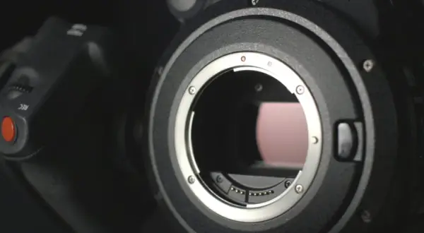 Dettaglio obiettivo di una fotocamera ad alta megapixel, con il pulsante REC visibile.