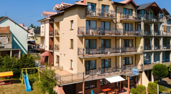 Hotel Neptun w Jastrzębiej Górze z placem zabaw i widokiem na morze.