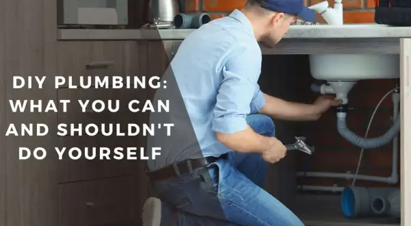 Man working on sink plumbing, part of a DIY bathroom remodel guide.