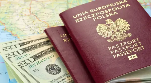 Dwa polskie paszporty, banknoty dolarowe i mapa. Planujesz podróż? Sprawdź, czy do Rumunii potrzebny jest paszport.