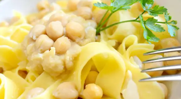 Ciceri e tria, un piatto pugliese con pasta fresca e ceci, guarnito con prezzemolo.