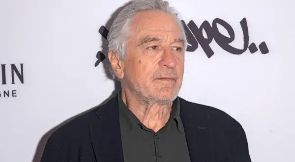Robert De Niro, ikona kina, w czarnym swetrze i marynarce. Jego filmy to klasyka gatunku.