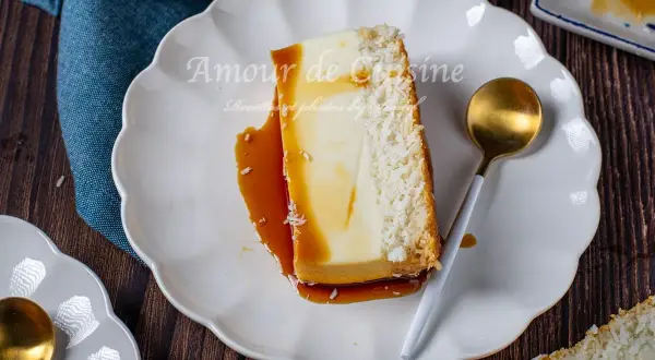 Tranche de flan coco antillais onctueux, nappé de caramel, avec une croûte de noix de coco râpée. Une cuillère dorée est posée à côté.