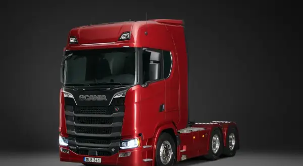 Un puissant camion Scania rouge, modèle V8, prêt pour de longues routes.