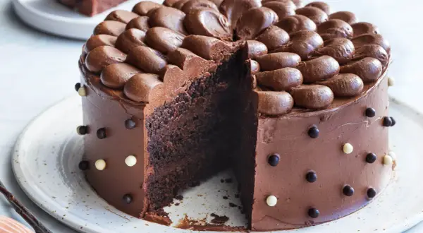 En saftig chokladtårta med chokladfrosting och dekorationer av chokladkulor. Perfekt för alla som älskar choklad och letar efter ett gott chokladtårta recept.