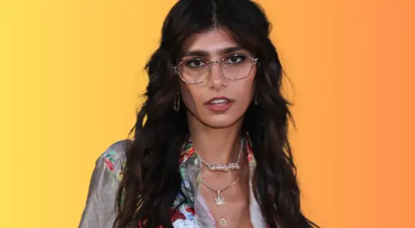 Mia Khalifa w okularach i kwiecistej koszuli, z naszyjnikami, wygląda jakby szykowała się do nagrania nowego mia khalifa song.