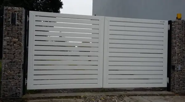 Nowoczesna, biała brama z poziomymi lamelami. Po lewej stronie widoczny enkoder, co to za urządzenie?
