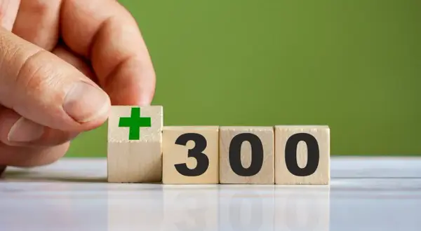 Dłoń układa kostkę z zielonym plusem obok kostek z napisem 300. Czy to 300 plus do jakiego wieku?