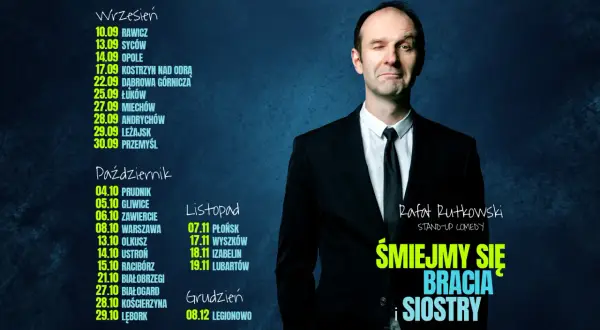 Rafał Rutkowski w czarnym garniturze, mrugając okiem, zaprasza na swój stand-up "Śmiejmy się bracia i siostry".