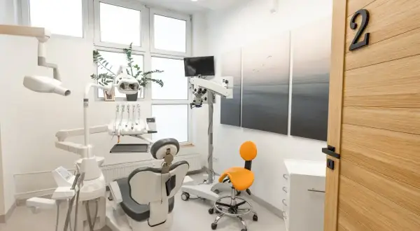 Nowoczesny gabinet stomatologiczny z fotelem, mikroskopem i drzwiami z numerem 2.