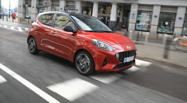 Czerwony Hyundai i10 na miejskim przejściu dla pieszych. Sprawdź atrakcyjną hyundai i10 cena!