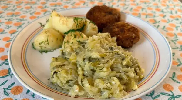 Młoda kapusta z koperkiem, przepis babci, podana z ziemniakami i kotlecikami. Pyszny, domowy obiad.