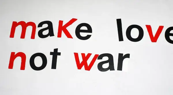 Napis "make love not war" w stylu pacyfista. Czerwone litery podkreślają przesłanie pokoju.